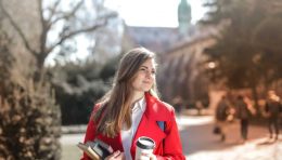 woman-in-red-coat-holding-notebooks-and-coffee-cup-3755760